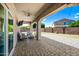 Inviting covered patio with outdoor seating, ceiling fan, and stone pavers, perfect for enjoying the outdoors comfortably at 2776 E Mews Rd, Gilbert, AZ 85298