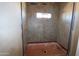 Close-up of a shower space with patterned tile work and a small window for natural light at 28551 N 257Th Ave, Wittmann, AZ 85361