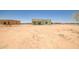 Light green single story home in the desert, awaiting landscaping, under a bright blue sky at 28583 N 257Th Dr, Wittmann, AZ 85361