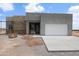 A modern home with a stone accent wall and fresh concrete driveway awaits landscaping at 28583 N 257Th Dr, Wittmann, AZ 85361