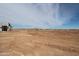 Image shows land surrounding construction site under a blue sky with clouds at 28583 N 257Th Dr, Wittmann, AZ 85361