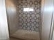 Modern shower boasting decorative patterned tile accent wall, enhancing the bathing experience at 28583 N 257Th Dr, Wittmann, AZ 85361