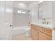 Bright bathroom featuring a tub with tiled walls, a showerhead, and a vanity with stylish fixtures at 28615 N 257Th Dr, Wittmann, AZ 85361