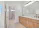 Well lit bathroom with double sinks, a modern vanity, and an opening to the tiled shower at 28615 N 257Th Dr, Wittmann, AZ 85361