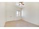 A sunlit bedroom boasts tile floors, a ceiling fan, and a window showcasing the outdoor view at 28615 N 257Th Dr, Wittmann, AZ 85361