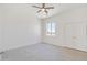 Spacious bedroom with tile floors, a ceiling fan, and a window with an outdoor view at 28615 N 257Th Dr, Wittmann, AZ 85361