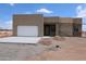 Contemporary home featuring a stucco exterior, attached garage, and desert landscaping at 28615 N 257Th Dr, Wittmann, AZ 85361
