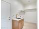 Clean laundry room featuring a sink with a modern gold faucet and convenient shelf storage at 28615 N 257Th Dr, Wittmann, AZ 85361
