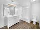 Clean bathroom with white vanity, bathtub, and wood-look floors at 40551 N Jodi Dr, San Tan Valley, AZ 85140