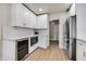 Spacious kitchen featuring white cabinets, stainless steel refrigerator and appliances and wood flooring at 545 W Windsor Ave, Phoenix, AZ 85003