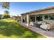 Spacious backyard with covered patio, grassy area, and mature trees at 633 S 77Th St, Mesa, AZ 85208
