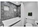 Clean bathroom with white toilet and bathtub, and marble tile at 6502 N Central Ave # B104, Phoenix, AZ 85012