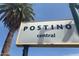 Prominent Postino Central sign with modern lettering set against a bright blue sky and palm tree at 6502 N Central Ave # B104, Phoenix, AZ 85012