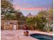 Outdoor kitchen, spa, and mountain views at sunset at 10102 E Saddle Horn Trl, Scottsdale, AZ 85255