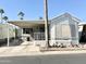 White single-wide manufactured home with covered porch and carport at 1027 S Prospector Dr, Apache Junction, AZ 85119