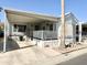 White single-wide manufactured home with covered porch and carport at 1027 S Prospector Dr, Apache Junction, AZ 85119