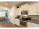 Modern kitchen with white cabinets, granite counters, and stainless steel appliances at 105 S 224Th Ave, Buckeye, AZ 85326