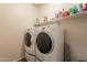 Bright laundry room with washer, dryer, and shelving at 105 S 224Th Ave, Buckeye, AZ 85326