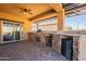 Outdoor kitchen with built-in grill, fridge, and sink at 105 S 224Th Ave, Buckeye, AZ 85326