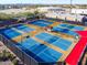 Aerial view of a tennis court complex with blue courts, shade structures, and desert landscaping in an active community at 105 S 224Th Ave, Buckeye, AZ 85326