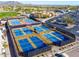 Aerial view of well-maintained tennis courts with blue surfaces in a community setting with mountains in the background at 105 S 224Th Ave, Buckeye, AZ 85326