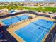 Aerial view of well-maintained blue tennis courts in a residential community with desert landscaping and mountain views at 105 S 224Th Ave, Buckeye, AZ 85326