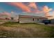 Large backyard with a shed and a view of the sunset at 10806 W King St, Avondale, AZ 85323