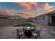 Backyard patio with fire pit and seating area under sunset at 10806 W King St, Avondale, AZ 85323