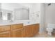 Well-lit bathroom featuring double sinks, wood cabinets, and a large mirror at 1179 N Granada Dr, Chandler, AZ 85226