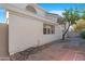 View of home exterior showing neutral stucco and covered patio area with desert landscaping at 1179 N Granada Dr, Chandler, AZ 85226