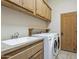 Laundry room with washer, dryer and wood cabinets at 11890 N 118Th St, Scottsdale, AZ 85259