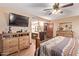 Main bedroom with a large TV, dresser, and en-suite bathroom access at 12450 W Fieldstone Dr, Sun City West, AZ 85375