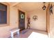 Inviting front porch with wreath, flowers and a white bench at 12450 W Fieldstone Dr, Sun City West, AZ 85375