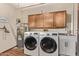 Bright laundry room, features washer, dryer, cabinets, and sink at 12450 W Fieldstone Dr, Sun City West, AZ 85375