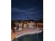 Night view of backyard pool, surrounded by a patio and landscaping at 12450 W Fieldstone Dr, Sun City West, AZ 85375