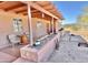 Covered front porch with seating area, stone planters, and desert landscaping at 13602 S Garnet Rd, Buckeye, AZ 85326