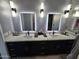 A sleek bathroom features double vanity sinks, modern lighting, black fixtures and elegant accents at 14426 N 39Th Way, Phoenix, AZ 85032