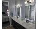 Bathroom featuring a double sink vanity with modern fixtures and backlit mirrors, creating a luxurious space at 14426 N 39Th Way, Phoenix, AZ 85032