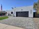 Modern home exterior with gray stucco, paver driveway, and two-car garage at 14426 N 39Th Way, Phoenix, AZ 85032