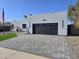 Contemporary home featuring a gray brick driveway, gray stucco, a garage, and manicured landscaping at 14426 N 39Th Way, Phoenix, AZ 85032