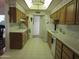 Galley kitchen with wood cabinets and tile floor at 16809 N Meadow Park Dr, Sun City, AZ 85351