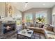 Bright living room featuring large windows with desert views, a fireplace, and a comfortable, curved sectional sofa at 17318 E Quail Ridge Dr, Fountain Hills, AZ 85268