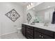 Double vanity bathroom with dark brown cabinets and patterned floor at 18173 W Cielo Grande Ave, Surprise, AZ 85387