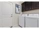 Laundry room with washer, dryer, and dark brown cabinets at 18173 W Cielo Grande Ave, Surprise, AZ 85387