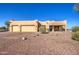 Single-story stucco home with three-car garage and desert landscaping at 20040 W Hunter Dr, Wittmann, AZ 85361