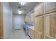 Laundry room with wood cabinets and tile flooring at 20040 W Hunter Dr, Wittmann, AZ 85361