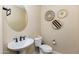 Small bathroom with pedestal sink, toilet and decorative wall baskets at 20473 W Park Meadows Dr, Buckeye, AZ 85396