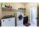 Bright laundry room, washer, dryer, and ample shelving at 20473 W Park Meadows Dr, Buckeye, AZ 85396