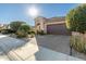 Bright, sunny view of home exterior; two-car garage, desert landscaping at 21720 N 265Th Dr, Buckeye, AZ 85396