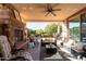 Relaxing patio with fireplace, seating area and ceiling fan at 21720 N 265Th Dr, Buckeye, AZ 85396